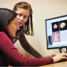 Photograph of researchers looking at MRI scans of a human brain