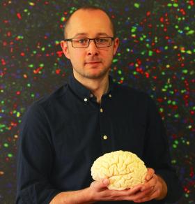 photograph of researcher with brain model